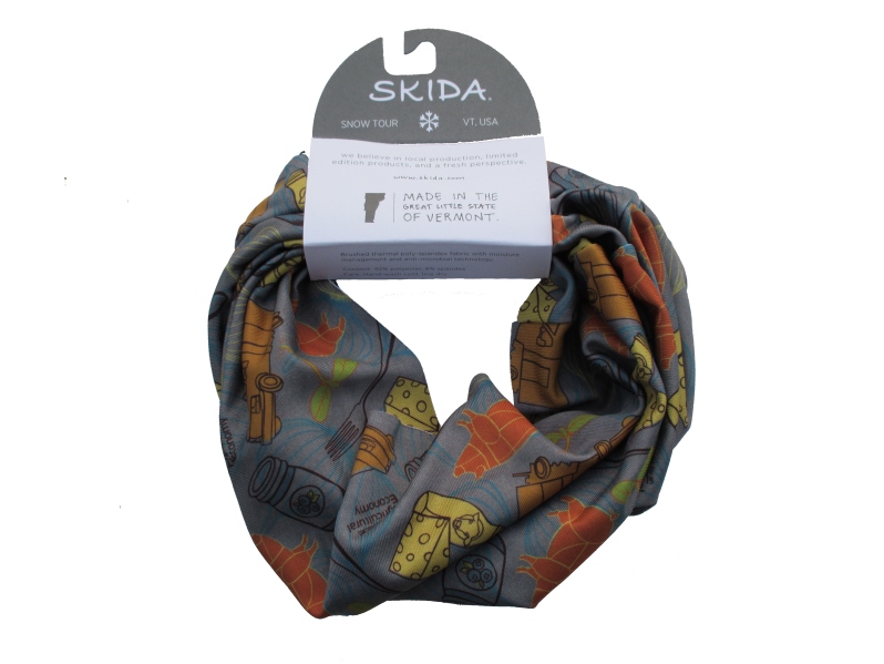 Product Description: Keep your neck warm and represent local art, agriculture, and outdoor gear. This exclusive CAE neckwarmer combines custom art by Jess Graham Studio with the lightweight warmth of the Skida Snow Tour. The fabric features hand-drawn images of a fork, sprout, pig, garlic, truck, jam, cheese, and milk. They all surround the words "Center for an Agricultural Economy" as a visualization of CAE's work to support local agriculture. Made from brushed jersey fabric, the unisex design and color palette is perfect on the mountain, or cozying up in front of the fire. The project was made possible through a generous donor, and all proceeds go to support CAE's programming.</br> CAE "Rural Roots" Skida Snow Tour